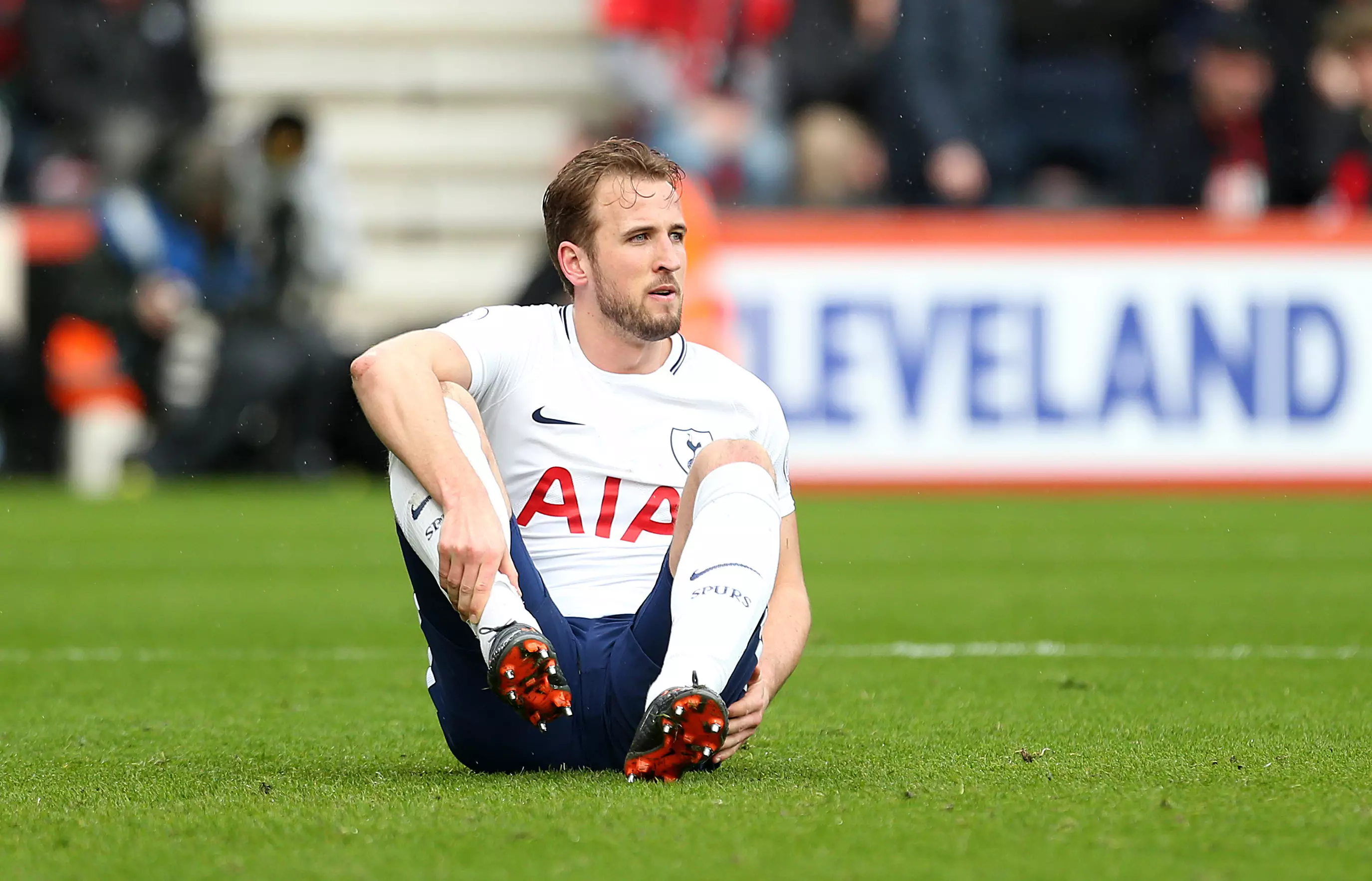 Kane sits on the pitch after suffering an injury. Image: PA