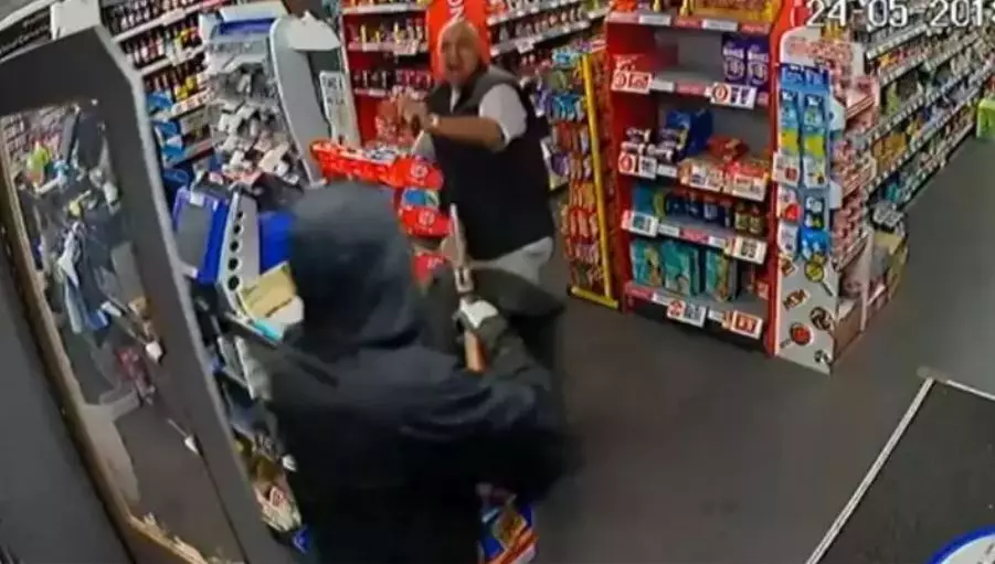 The shopkeeper using a magazine to defend himself... from a gun.