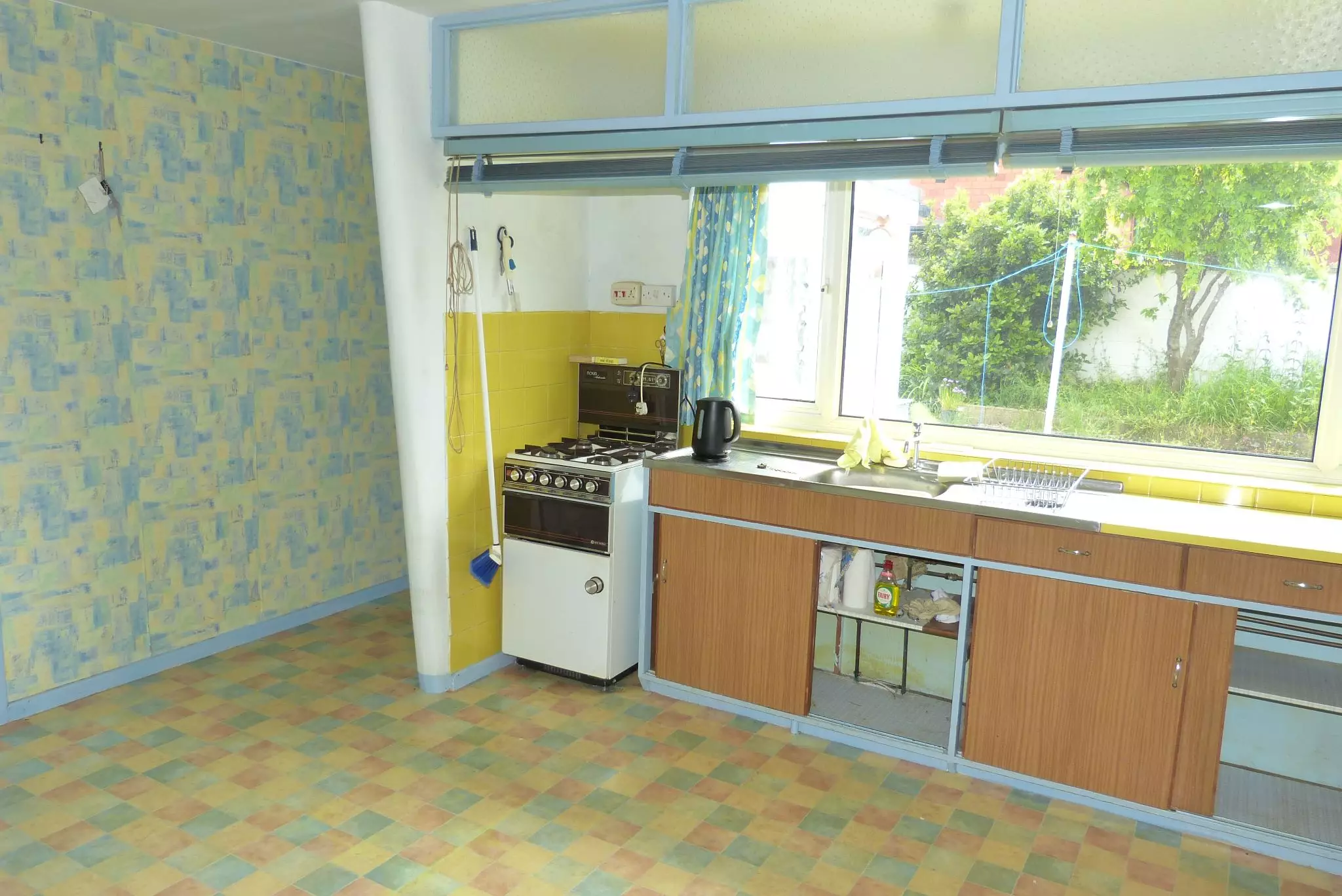 The kitchen has retro units and a hatch through into the dining room.
