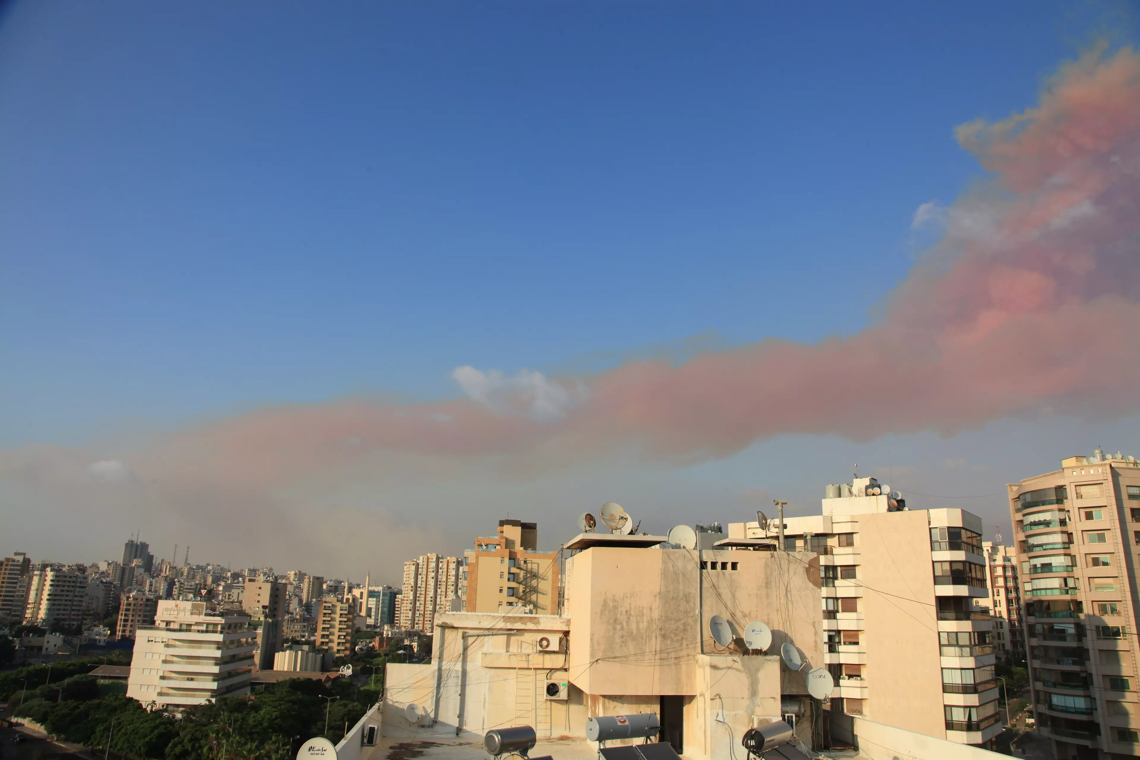 The large plume of pink smoke rises over Beirut.