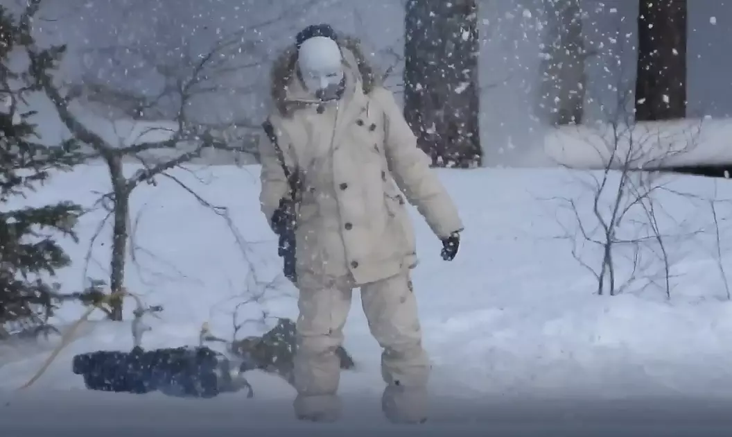 The masked man can be seen firing off rounds into the snow.