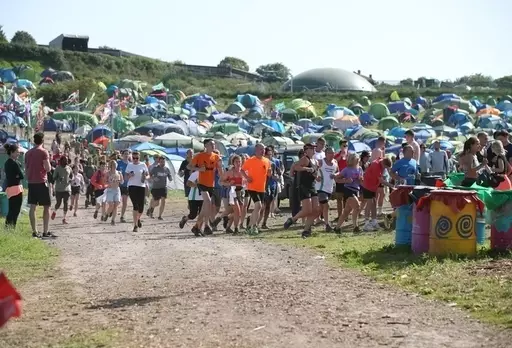 Festival goers take part in a mass early morning run during the Glastonbury Festival.