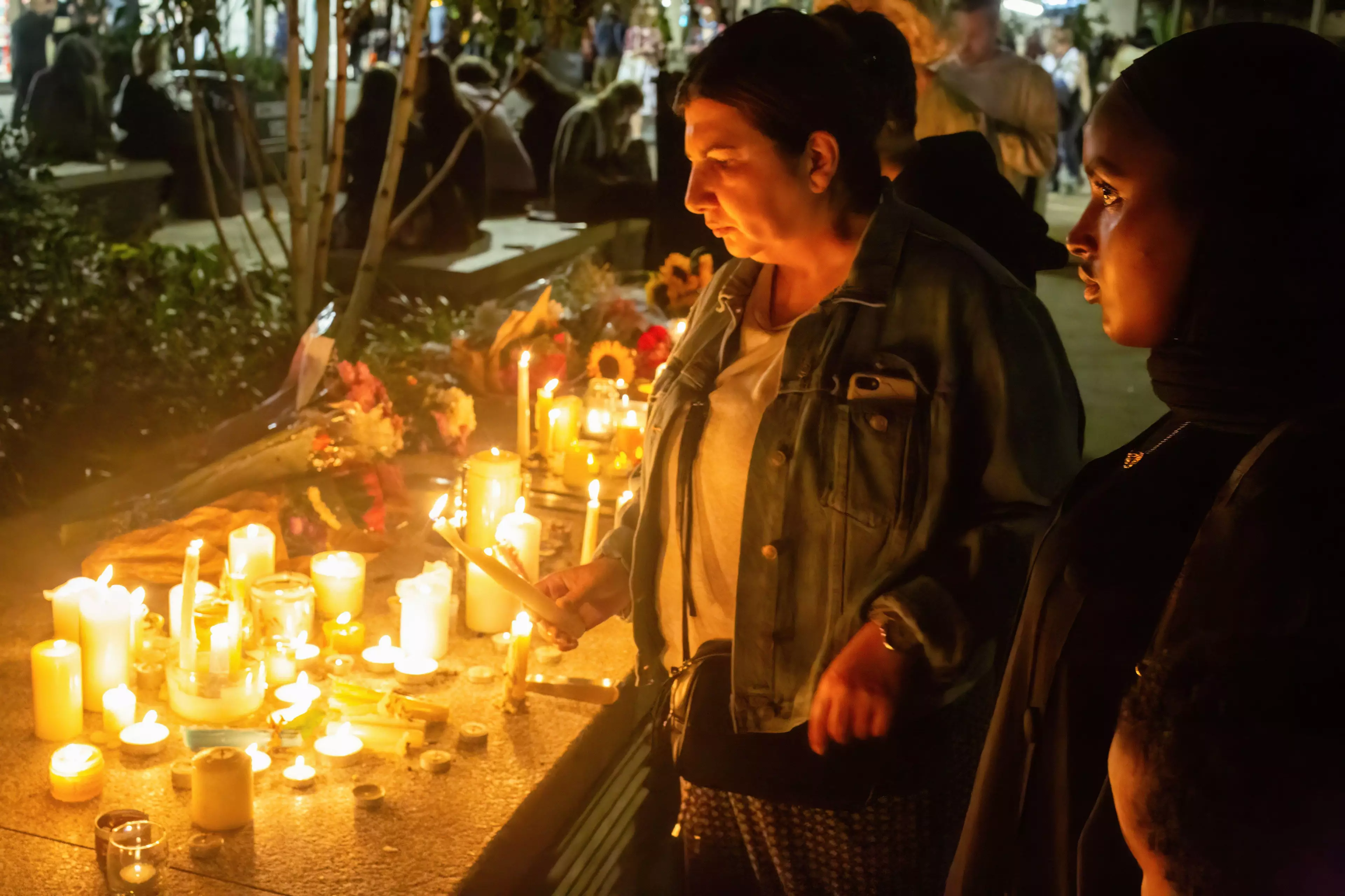 A woman lights a candle during Sabina Nessa's vigil on Friday.