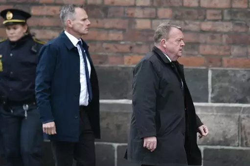 Denmark's Prime Minister Lars Loekke Rasmussen, right, arrives for the funeral service for the three children of the CEO of clothing brand Bestseller, Anders Holch Povlsen and wife Anne.