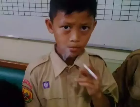 One of the children smoking after his headteacher gave him a cigarette as punishment.