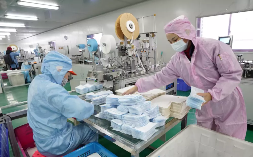 Workers make facial masks at the workshop of a company in Wuhan, central China's Hubei Province.