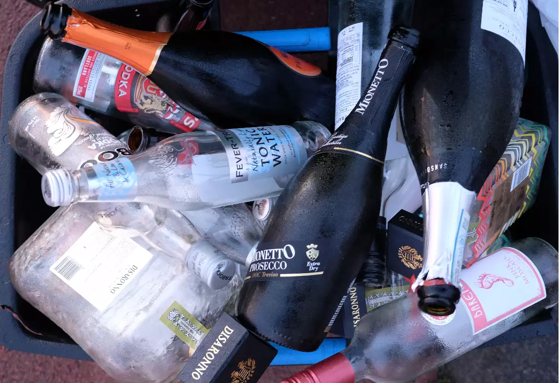 Stock image of empty bottles in a recycling bin.