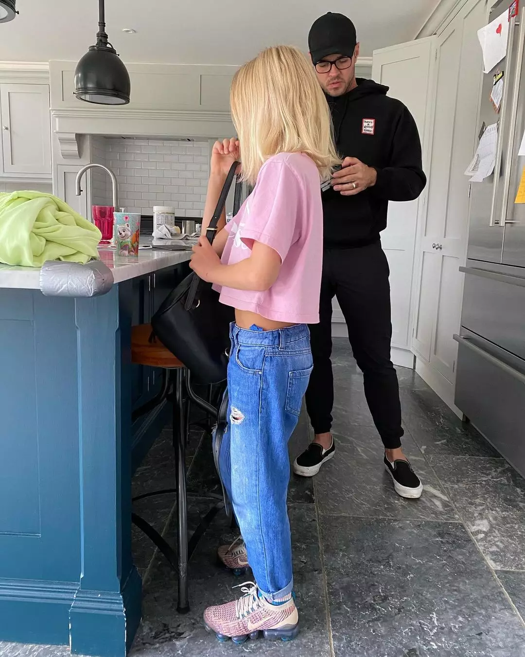 The snap shows Ace wearing a pink tee, blue jeans and pastel Nike trainers, with shoulder length hair (