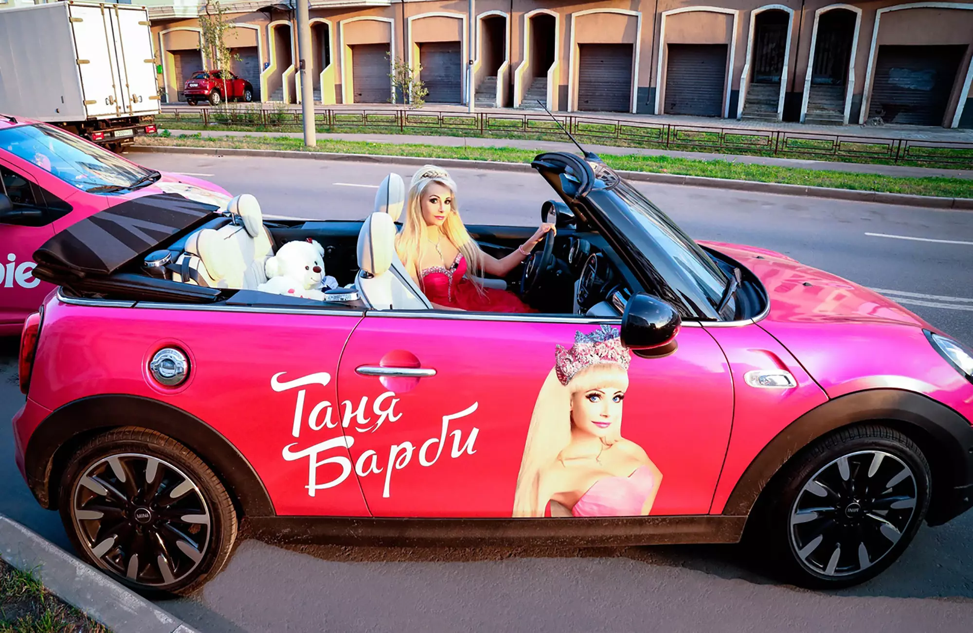 Tatiana driving her pink (obviously) Mini Cabrio.