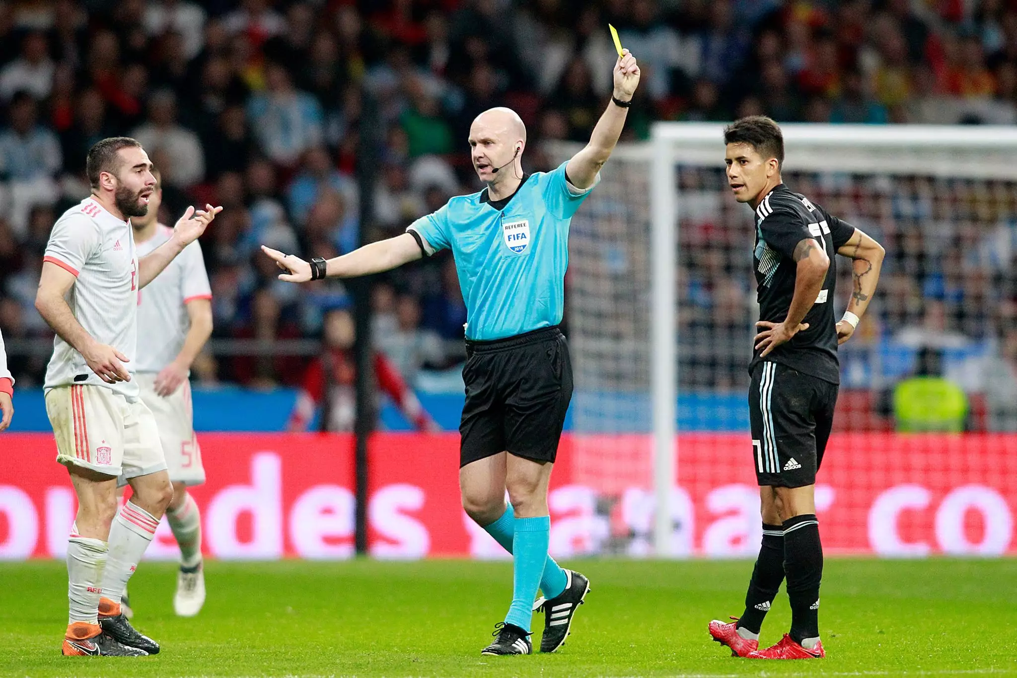 Taylor shows a yellow card to Argentina's Meza. Image: PA