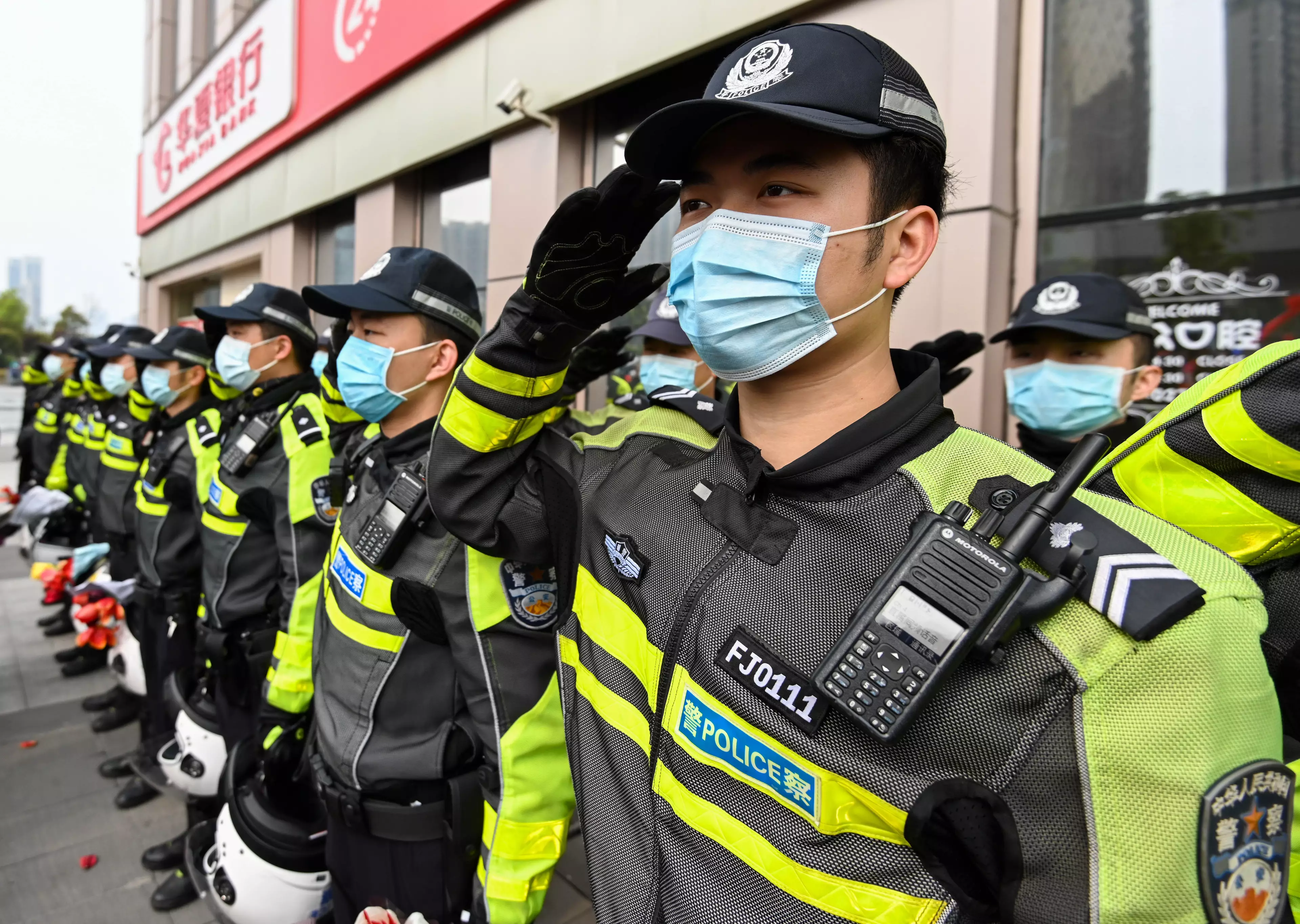 Policemen salute to medics from Guangdong Province before departure in Wuhan.