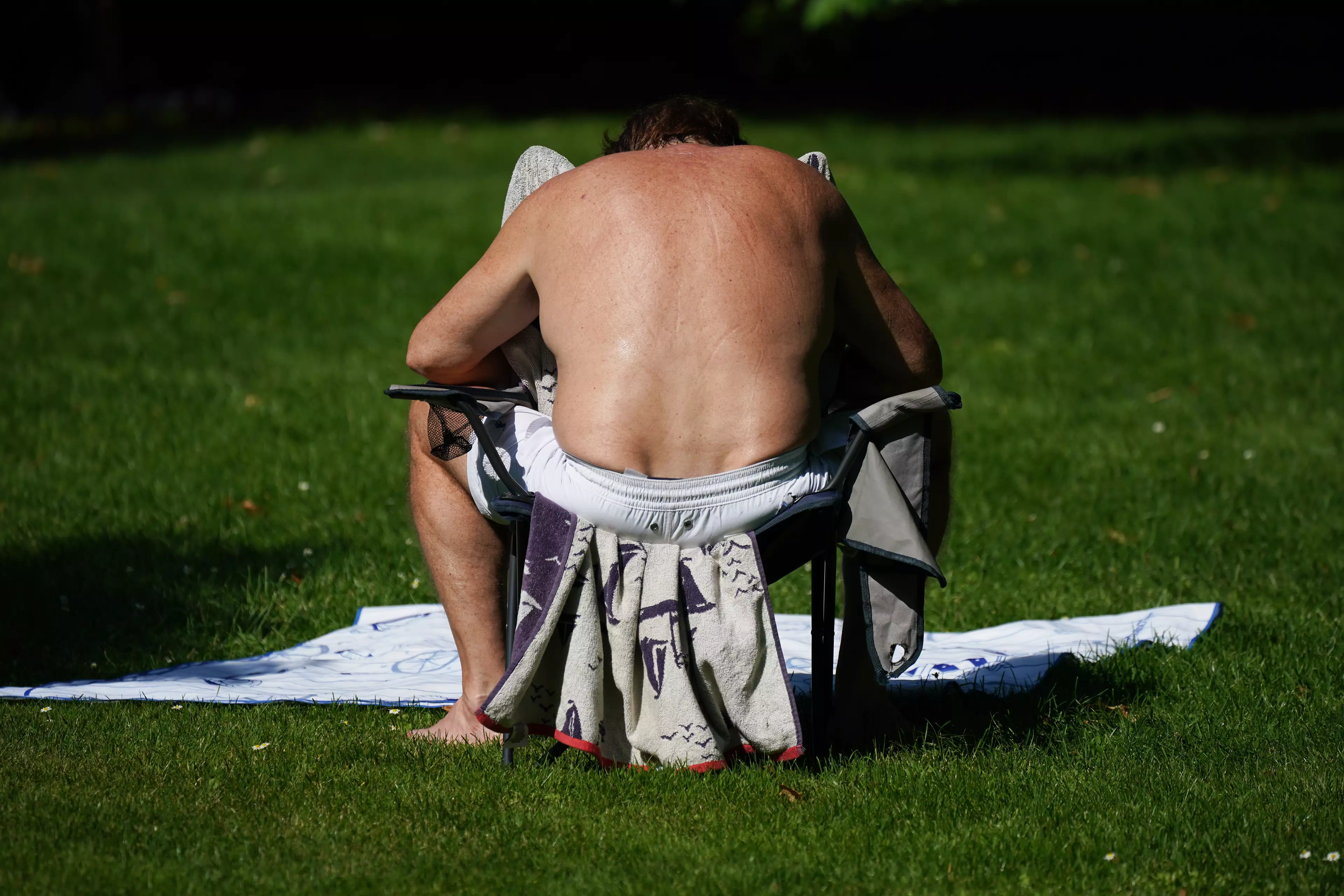 A man sunbathing in St James' Park, London.