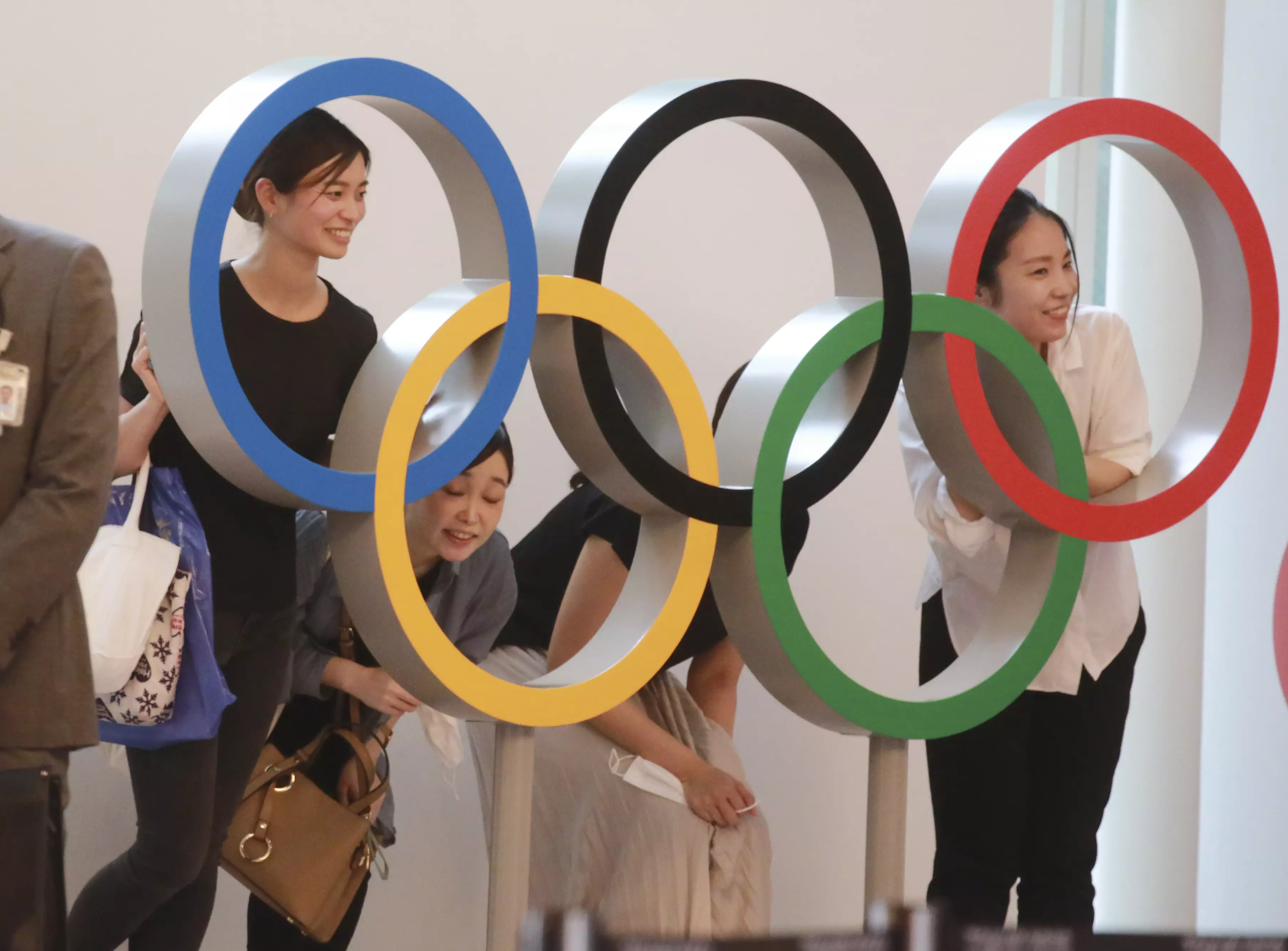 Spectators pose for photo with the Olympics Rings display at Haneda International Airport in Tokyo (