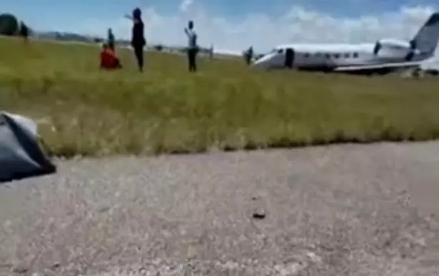 The plane was nose-down in the grass beside the runway.