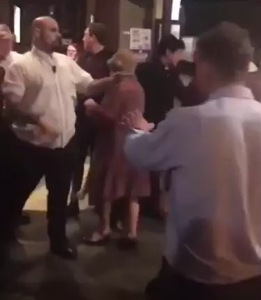 The woman braved the mass brawl to make her way to the bar.