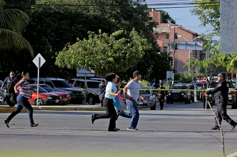 People running in the street following a shooting attack in Cancun.