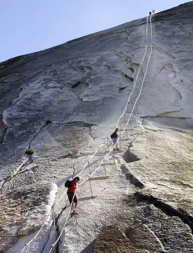Hikers descend the cable route after climbing to the summit of Half Dome.