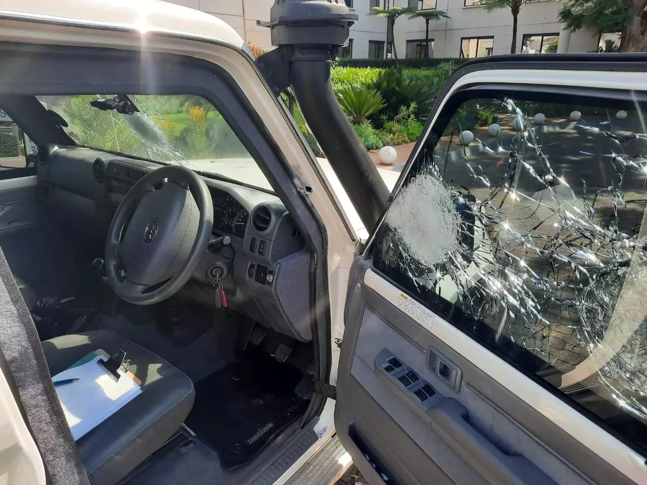 The car's window shattered by bullets.