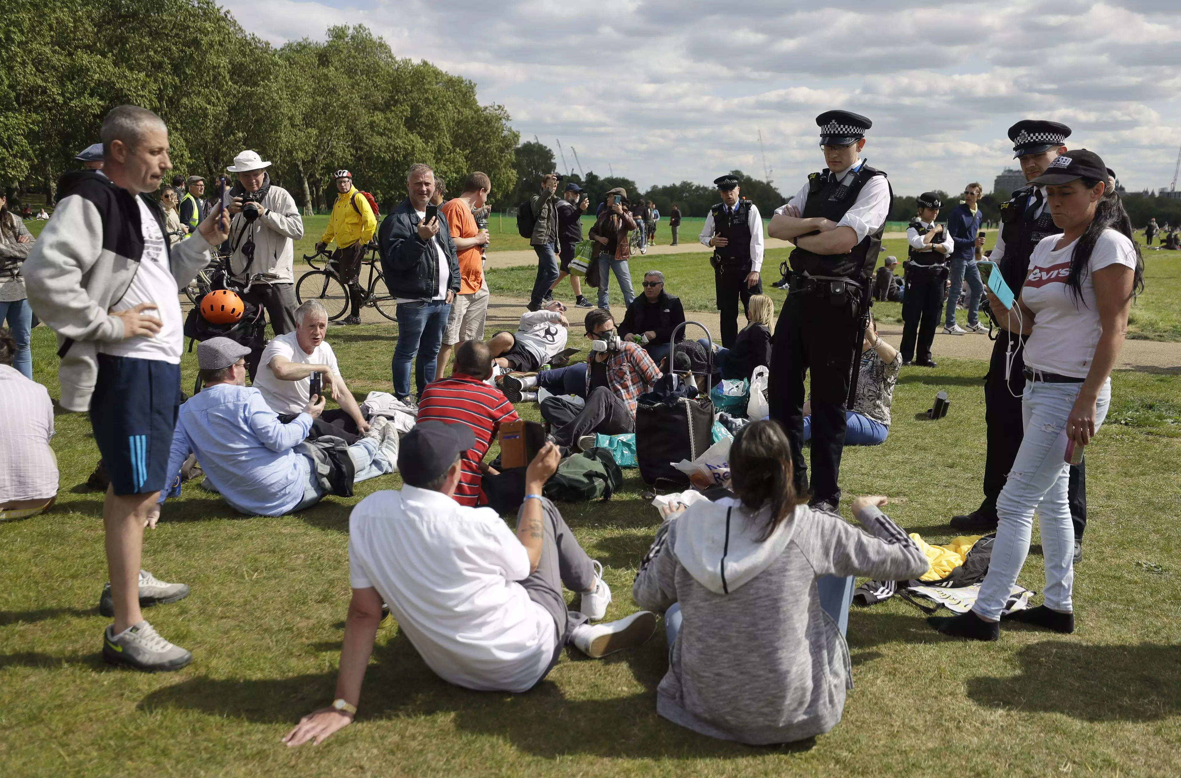 Police approach people protesting the lockdown in Hyde Park, London.