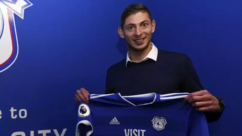 Emiliano Sala pictures with a Cardiff City shirt.
