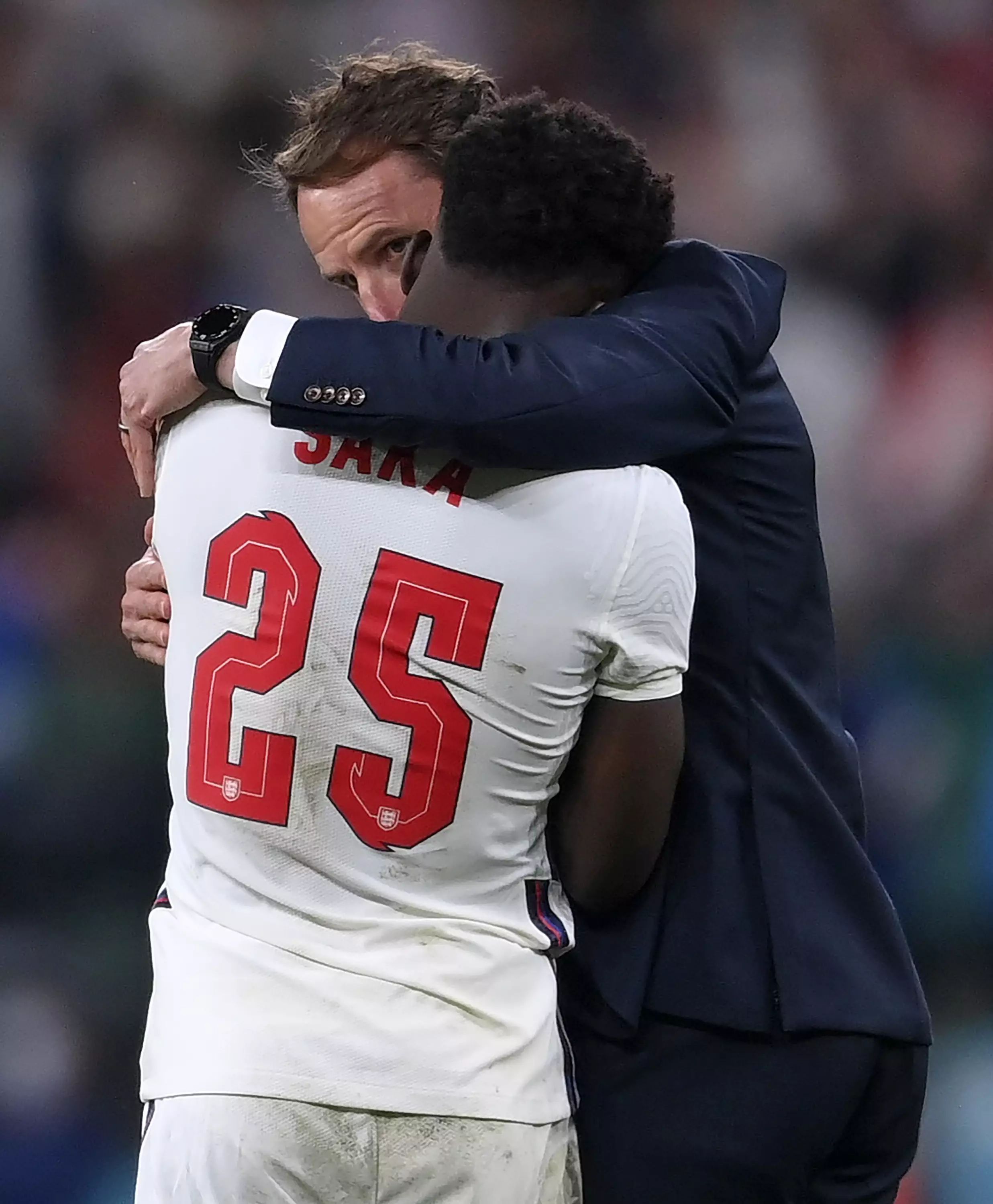 England's manager Gareth Southgate, right, hugs England's Bukayo Saka.