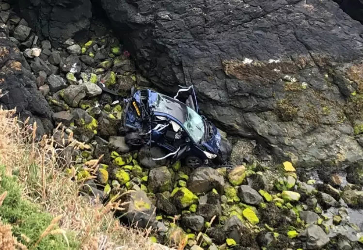 The car was seriously smashed up after it plunged off the cliff edge.