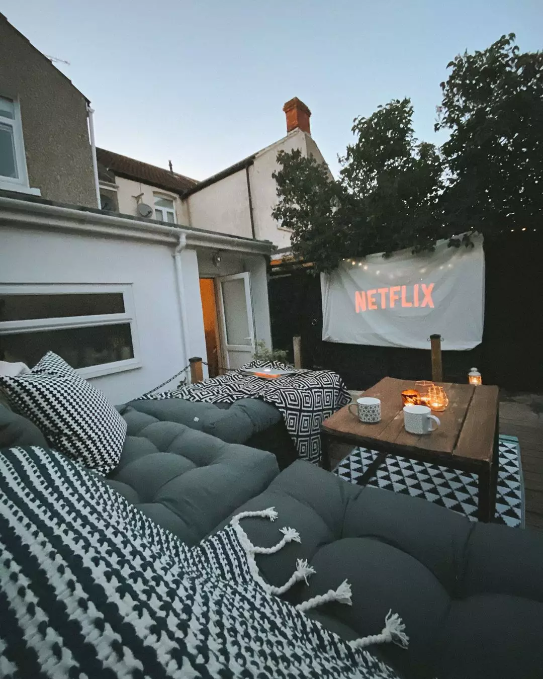 An outdoor cinema with a bed sheet for the screen.