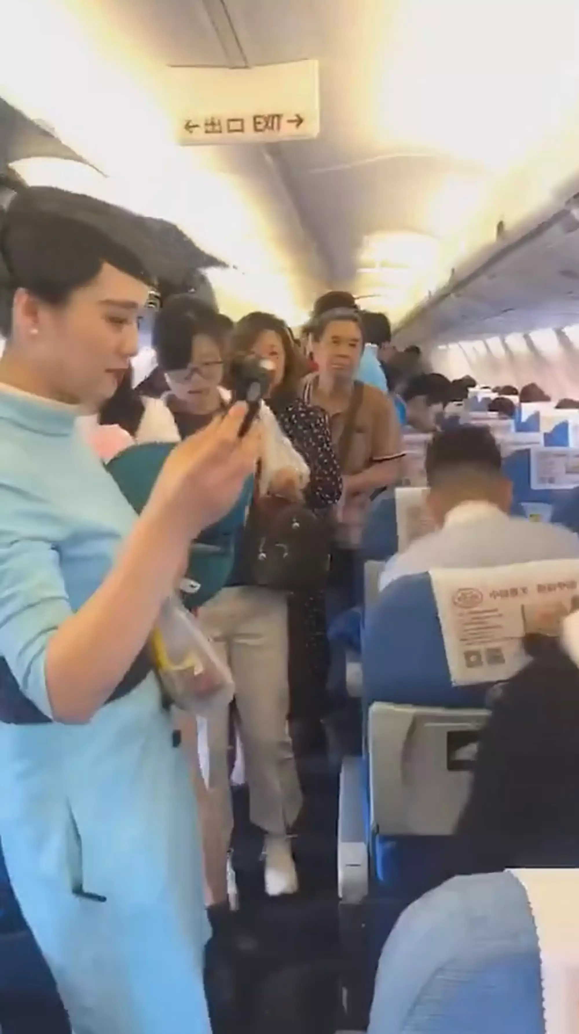Cabin crew and confused passengers inside the delayed Xiamen Airlines flight.