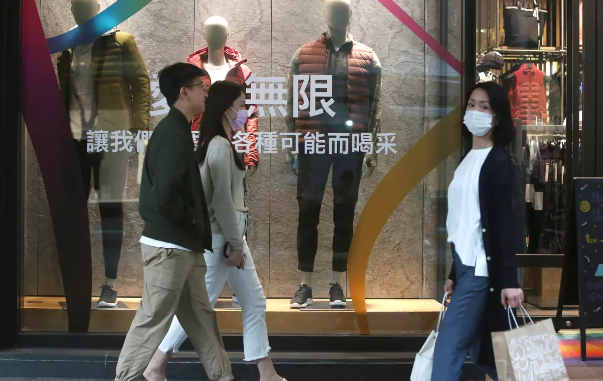 People wear face masks as they walk through a shopping district in Taipei, Taiwan.