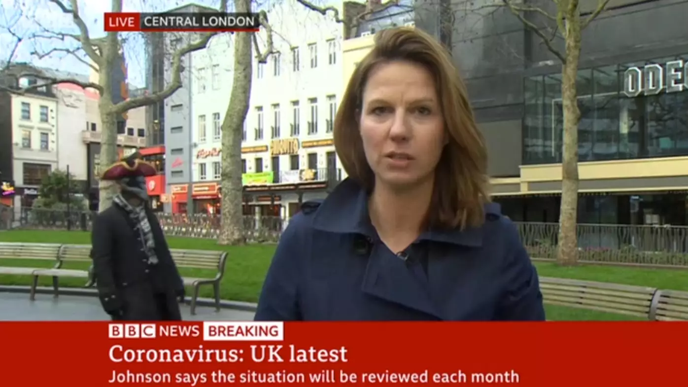 Person In Fancy Dress Walks Around Behind BBC Reporter During Live Broadcast