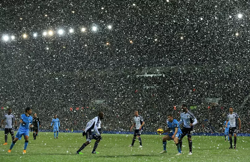 Snow falls as the match is played between West Brom and Man City.