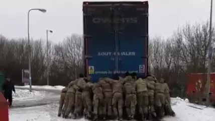 Royal Marines Help Push A Stuck Lorry Uphill In The Snow