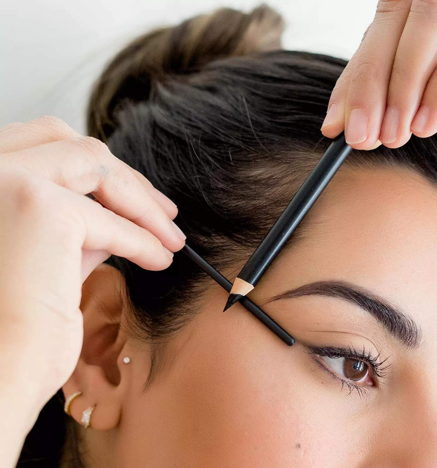 Use a ruler or brow pencil to draw your guide lines, aligning your brow tail with the outer corner of your eye (