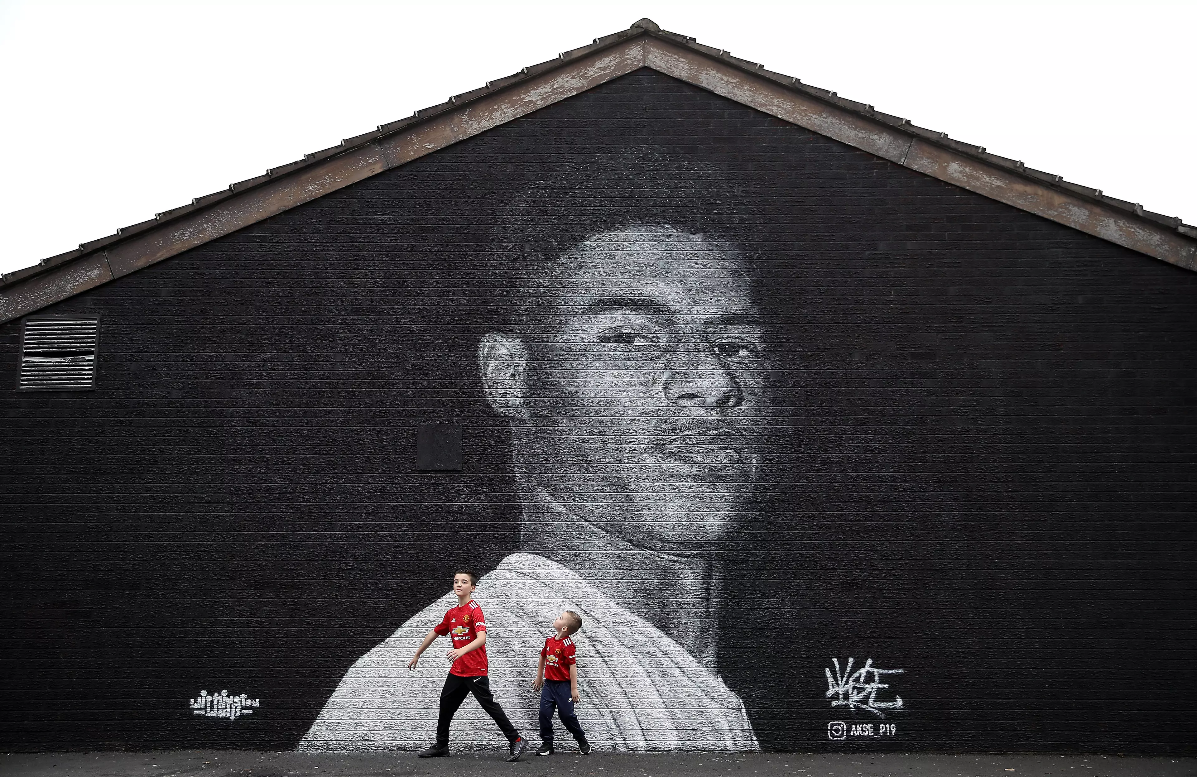 Young Manchester United fans have their picture taken in front of the mural. Image: PA Images