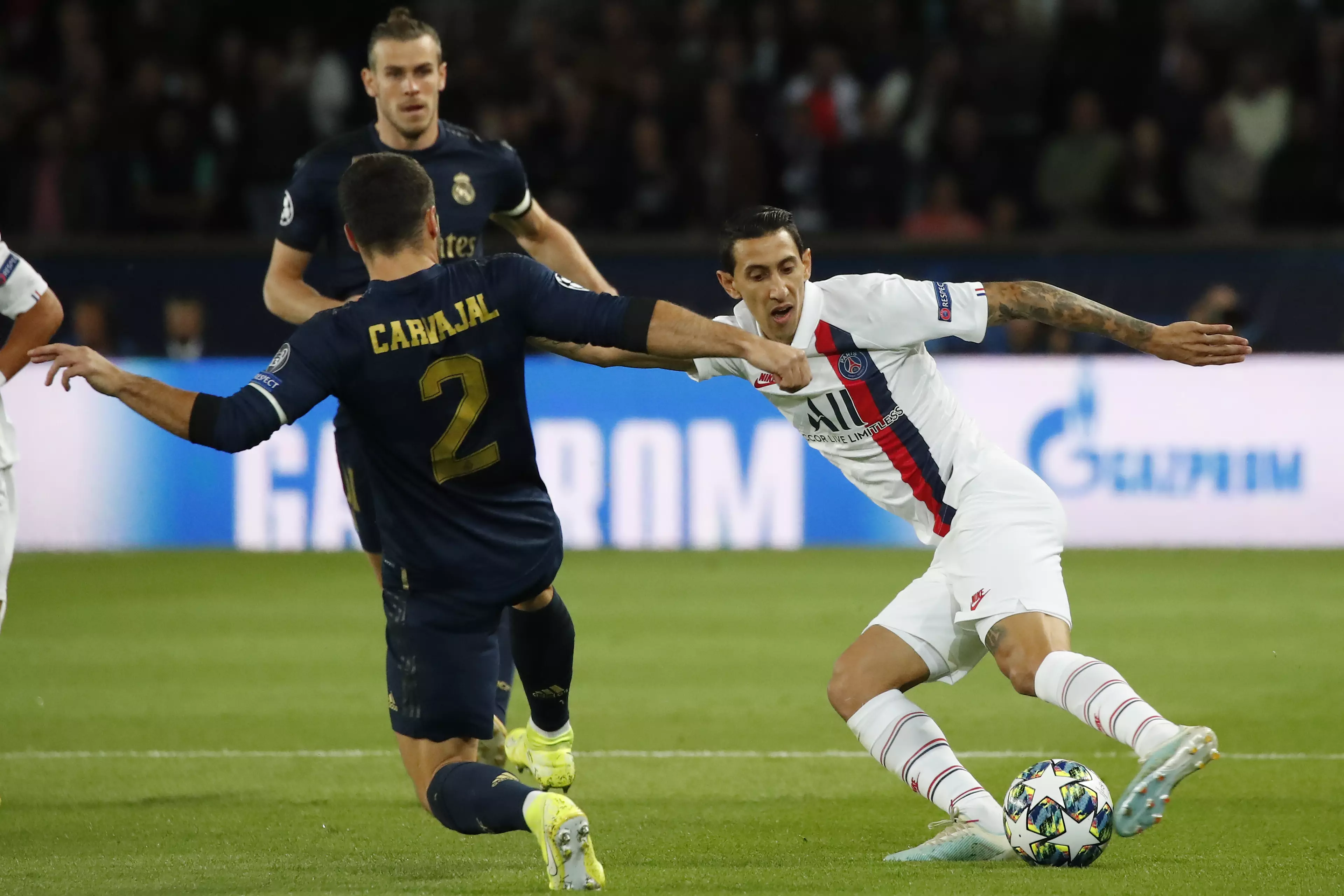 Angel di Maria in PSG white takes on Real Madrid's Dani Carvajal dressed in blue