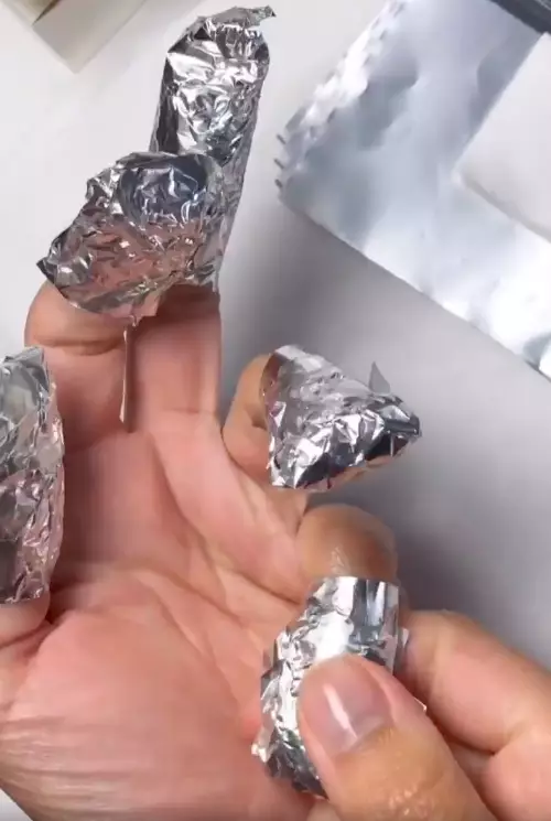 Wrap each finger in a cotton pad soaked with acetone and top with tin foil (