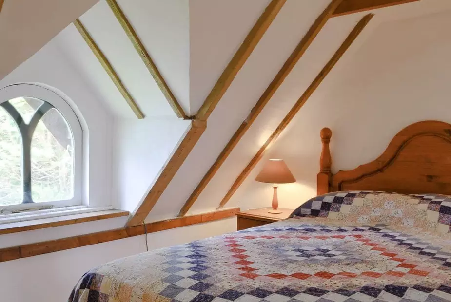 The upstairs loft bedroom features log beam ceilings (