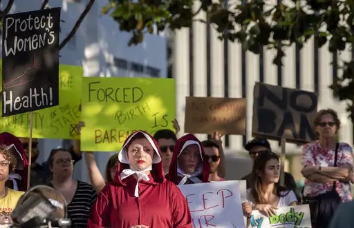 Margeaux Hartline, dressed as a handmaid, protests against a ban on nearly all abortions outside of the Alabama State House.