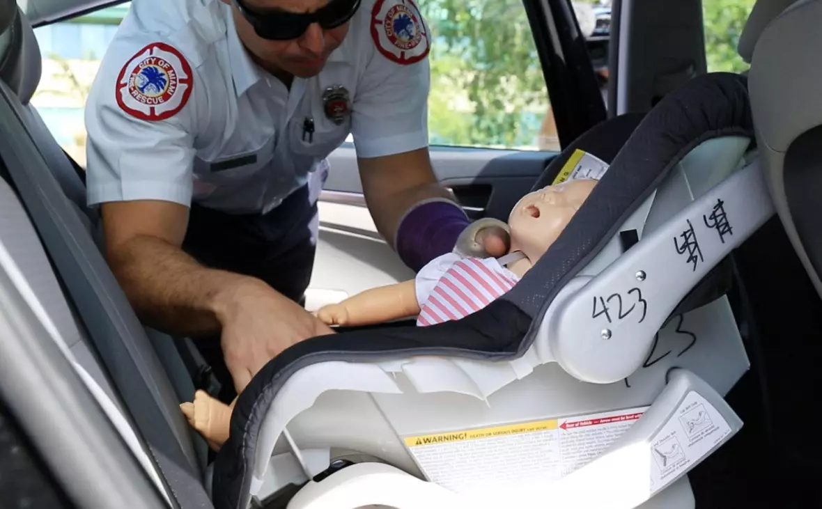City of Miami Fire Rescue member removes test dummy used for rescue demonstration on methods to save the life of an infant or pet in case of emergency (Photo by Sebastian Ballestas/Miami Herald/TNS).