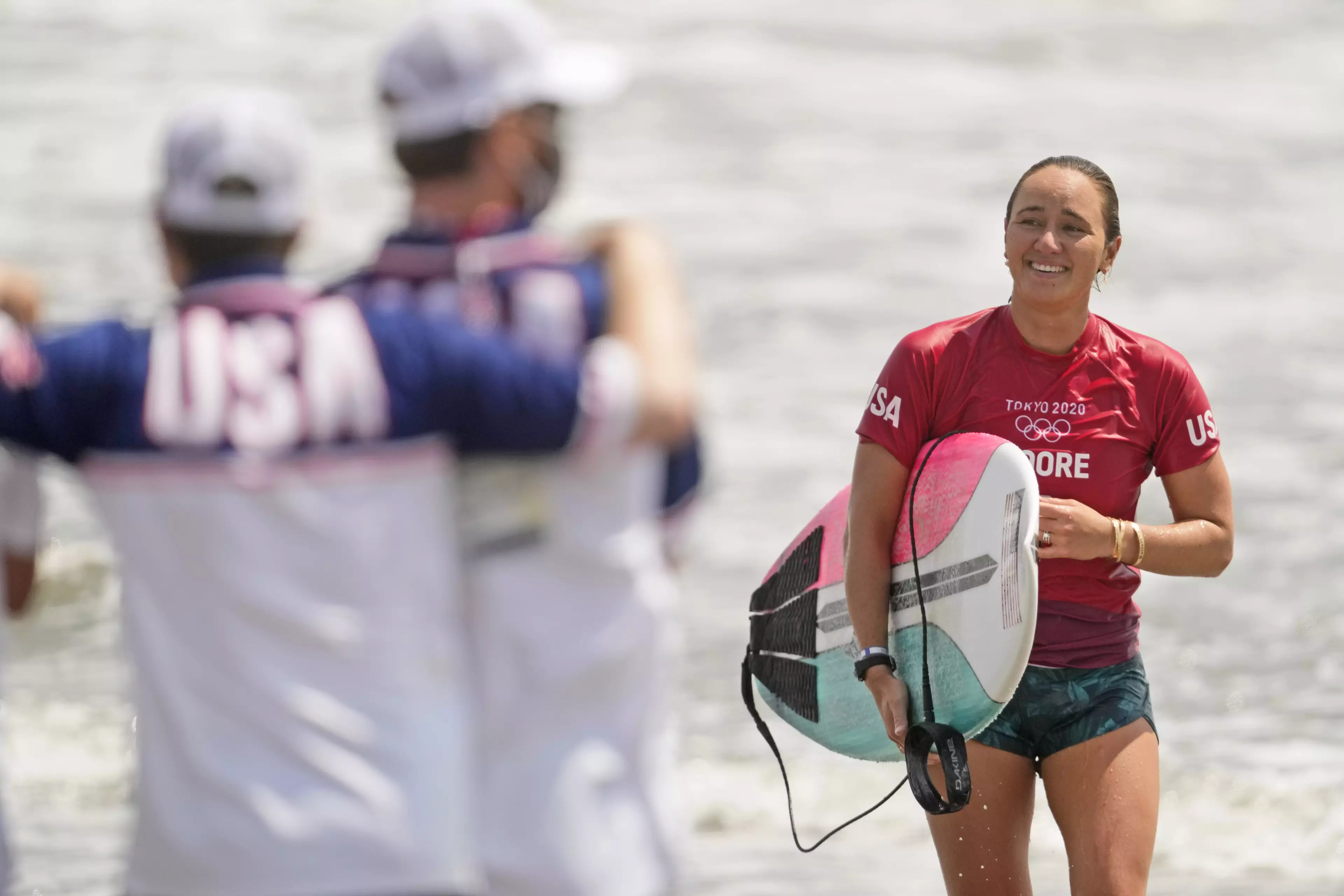 Carissa Moore, of the United States, smiles after wining her heat during third round of women's surfing competition (