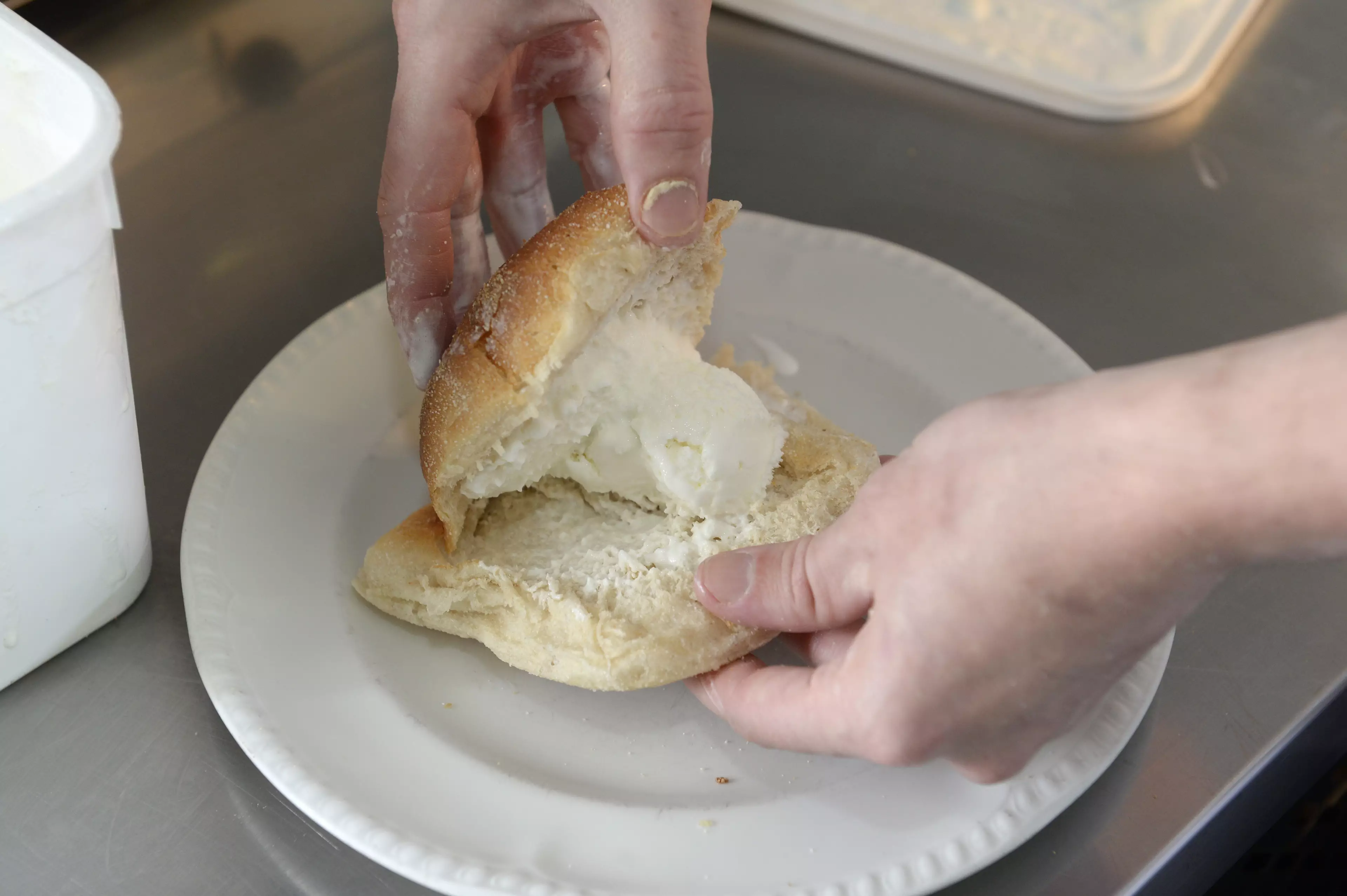A scoop of ice cream is placed in a bread roll, then deep fried.