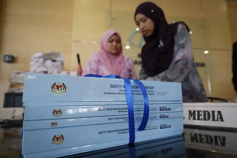Staff arrange the copies of the final investigation report on missing flight MH370 in Putrajaya.