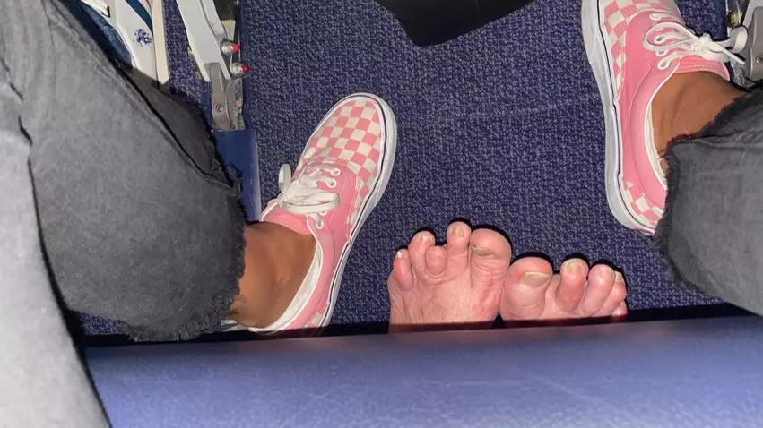 Traveller Shocked As Passenger Behind Them Sticks Their Feet Through