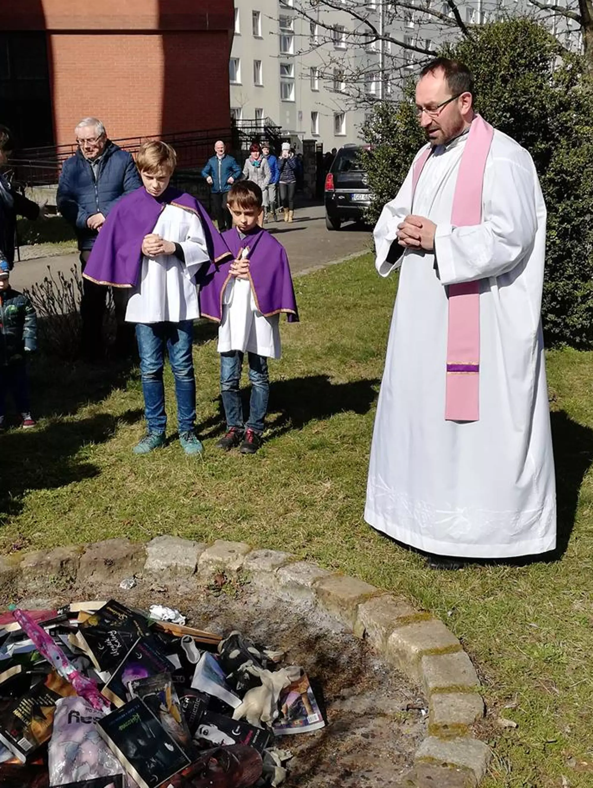 Priests and altar boys helped burn the books.
