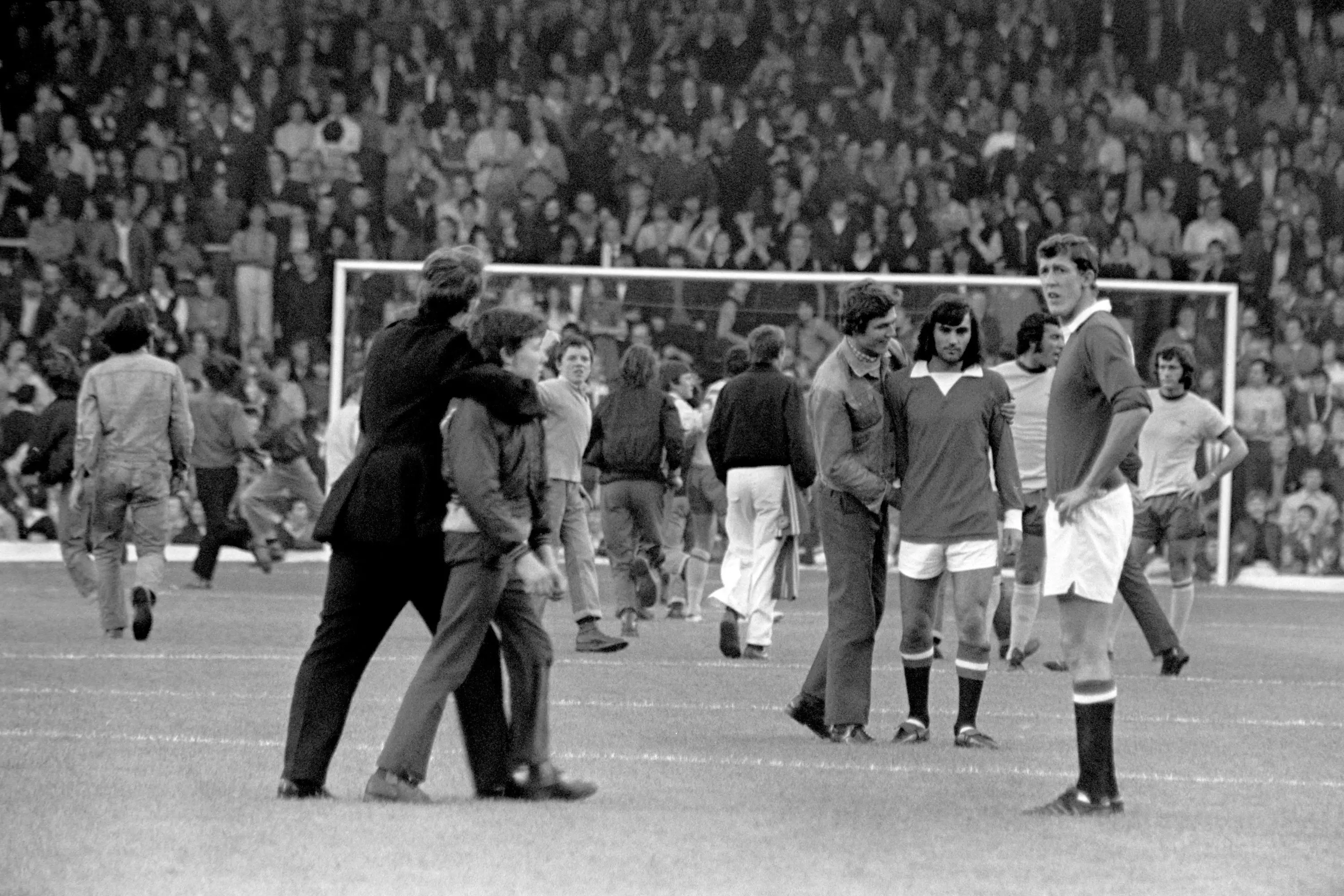 Players, including George Best, look on as fans invade the pitch. Image: PA Images