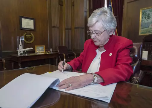 Alabama Gov. Kay Ivey signing a bill that virtually outlaws abortion in the state.