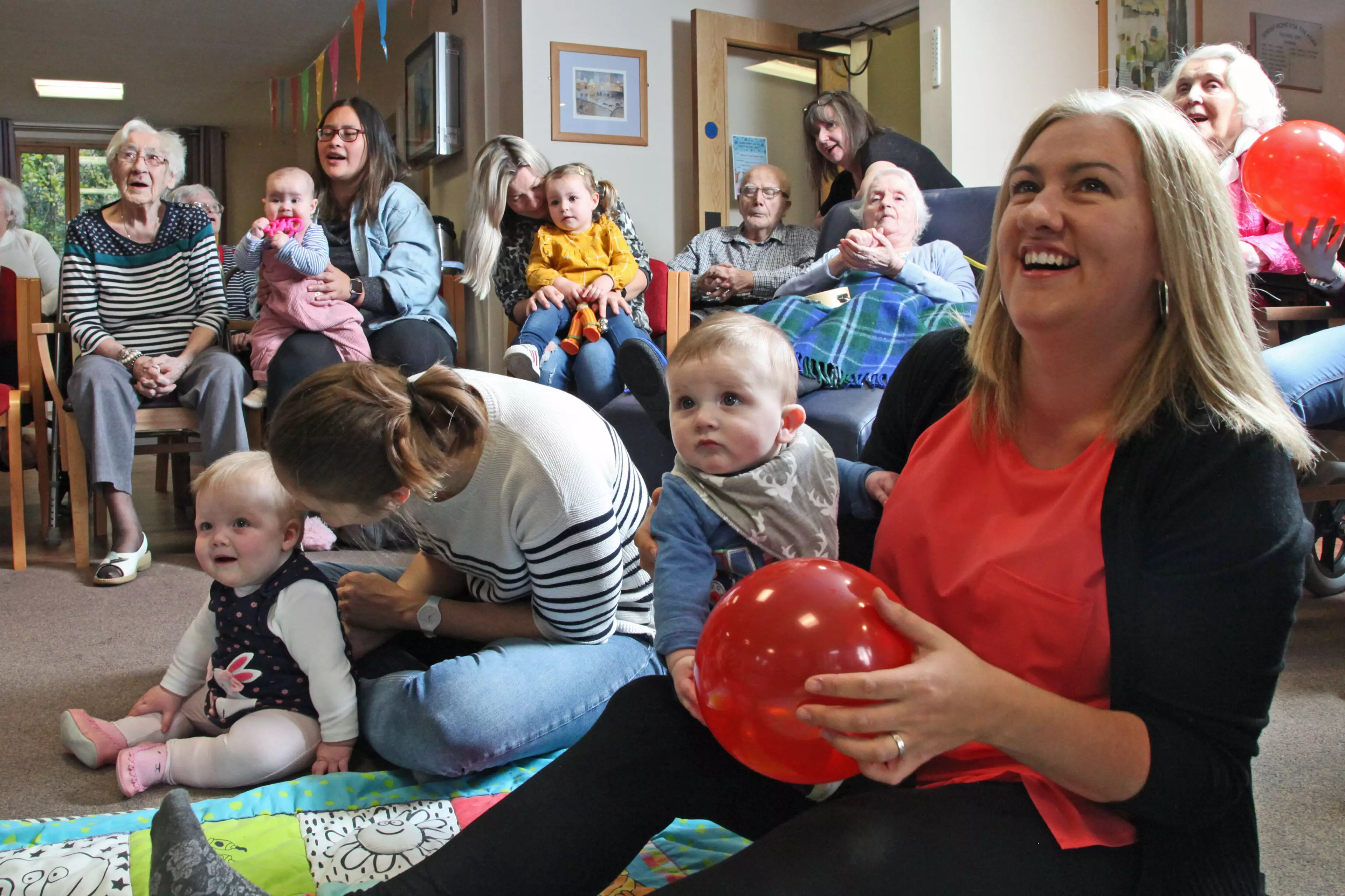 It's a music group where mums and their babies visit care homes and spend time with the elderly. (