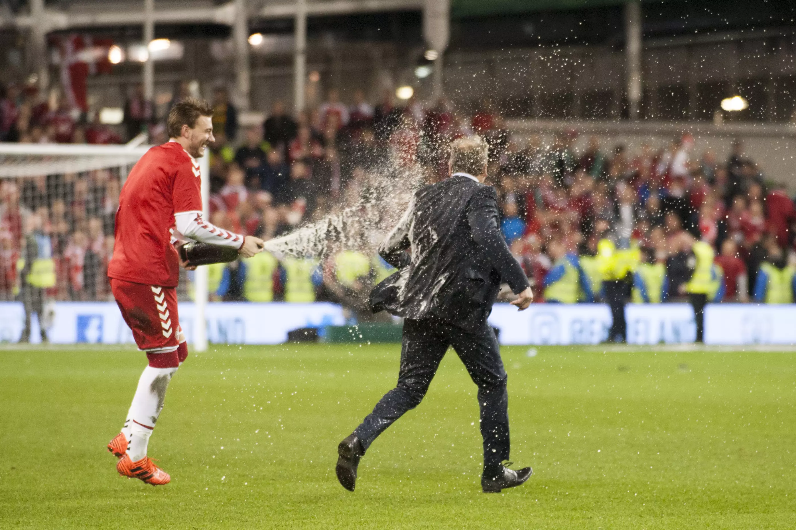 Bendtner sprays the Denmark coach with Champagne. Image: PA
