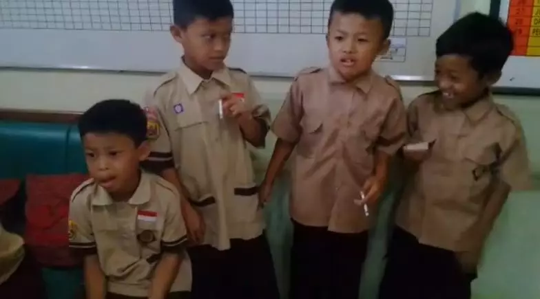 The children laughing as they're made to smoke as a punishment for smoking.