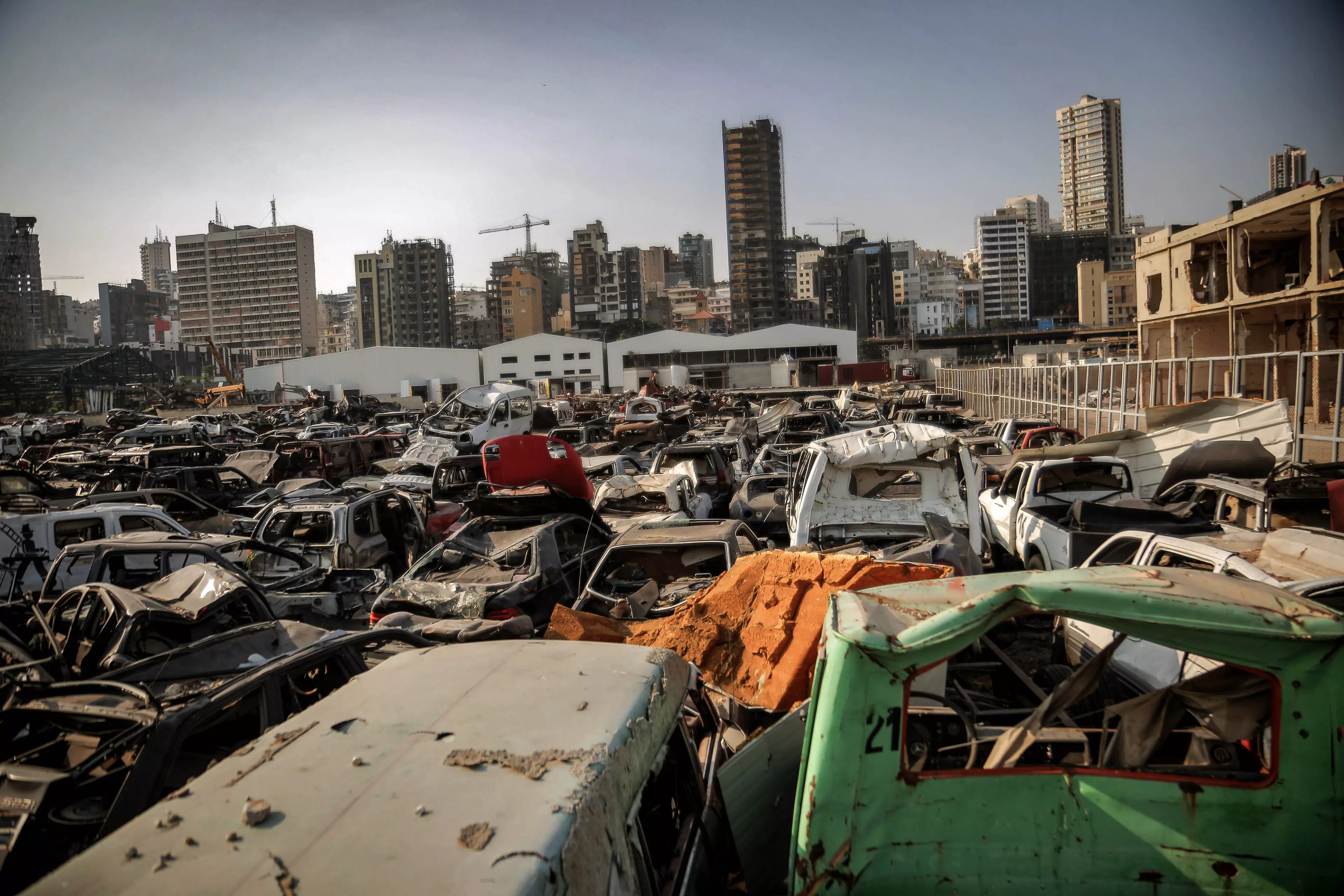 Destroyed cars still litter the Port of Beirut one year later.
